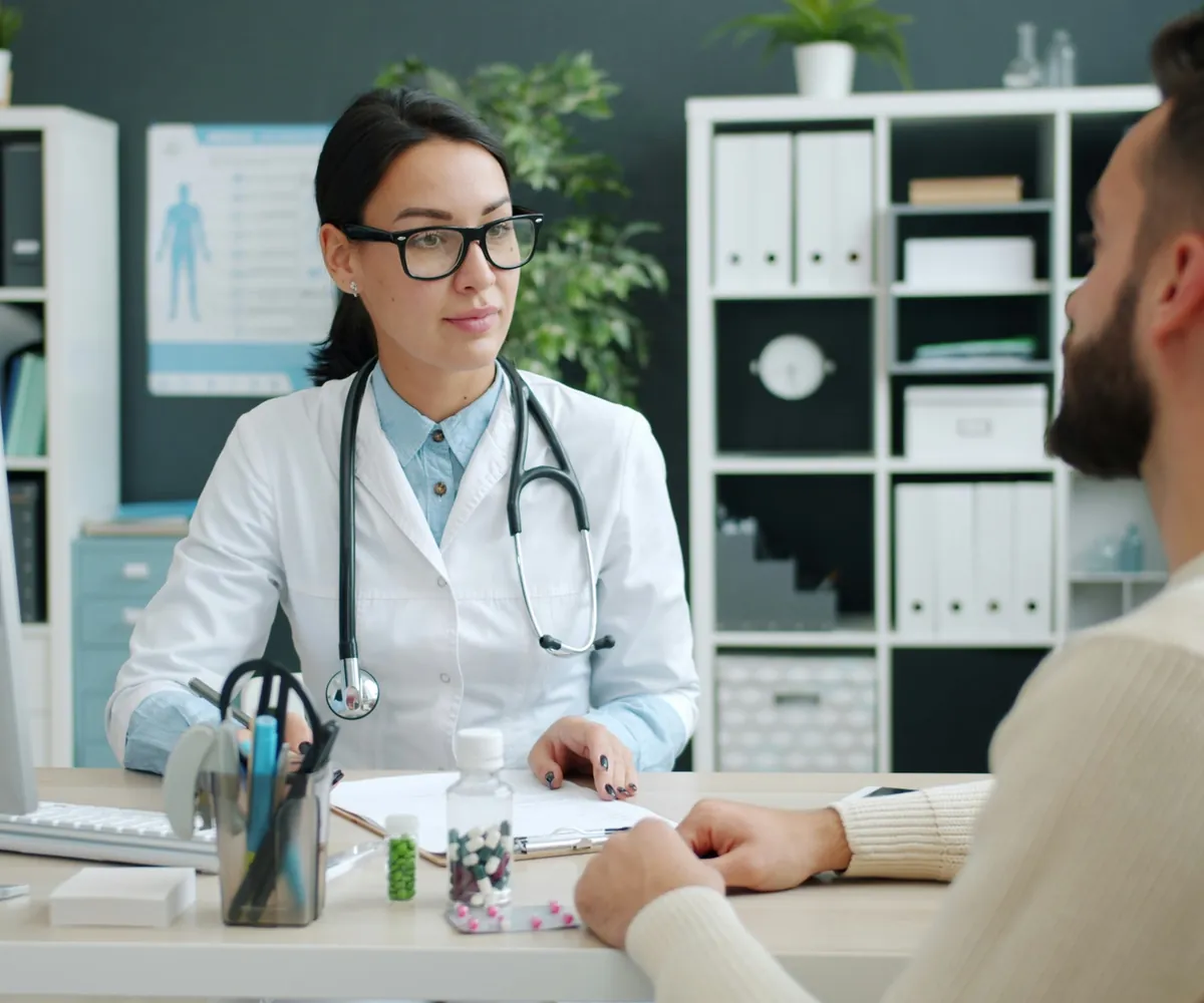 Doctora conversando con un paciente en su consulta