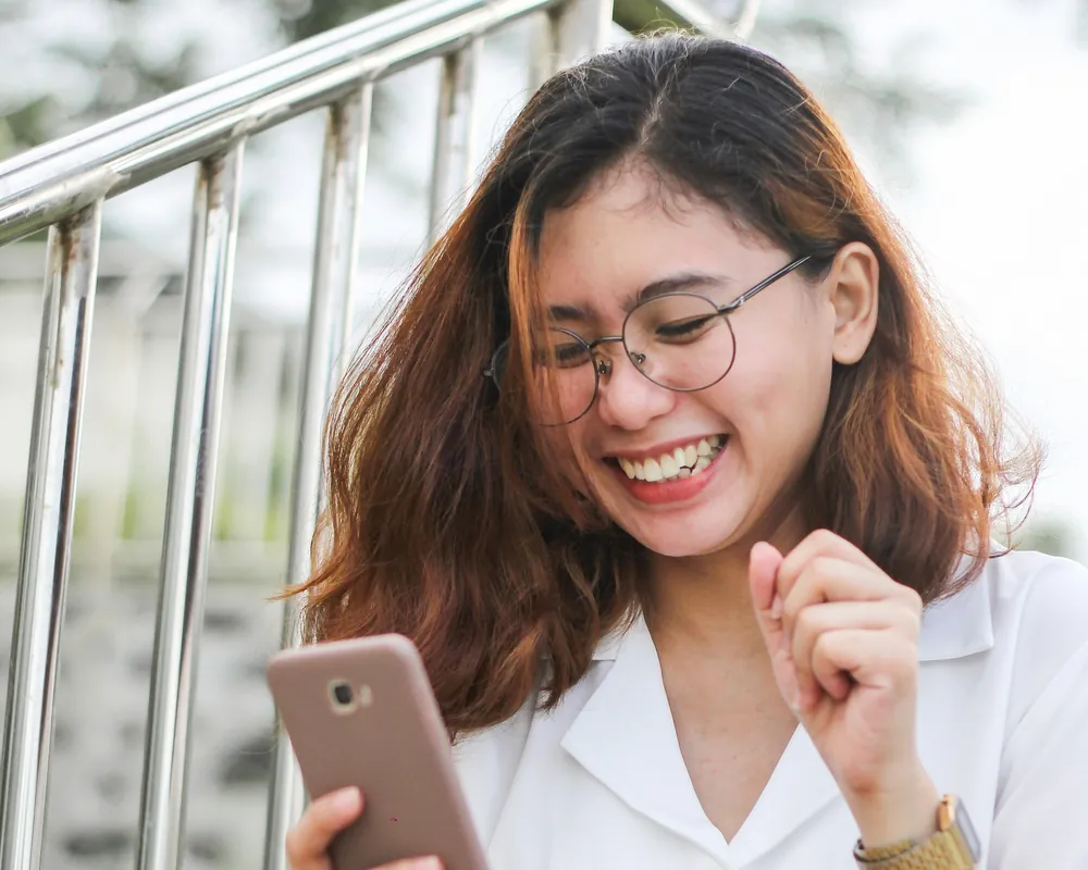 Mujer feliz mirando su teléfono